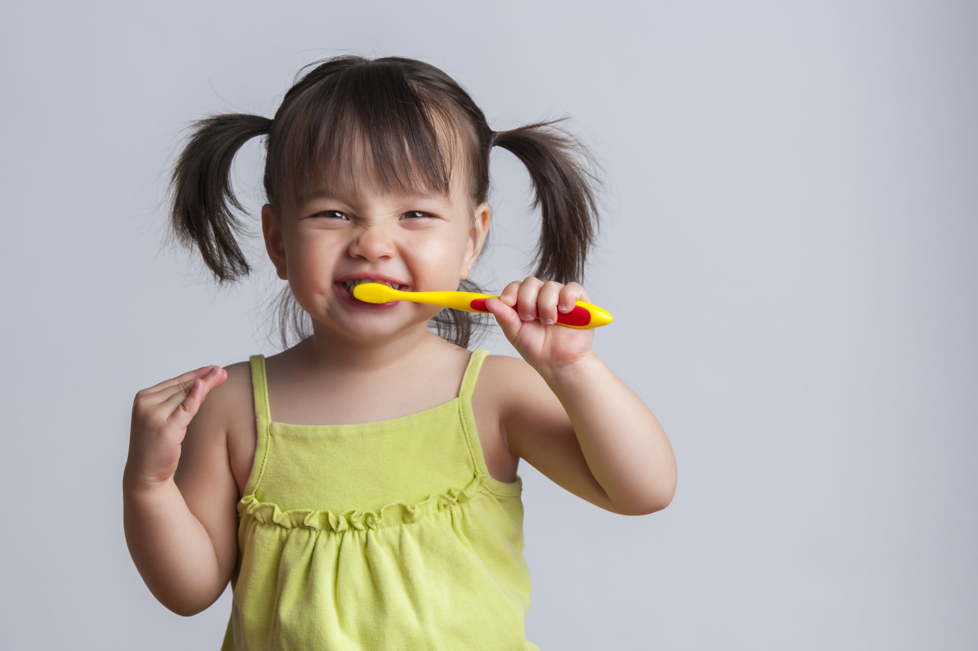 happy little girl brushing teeth