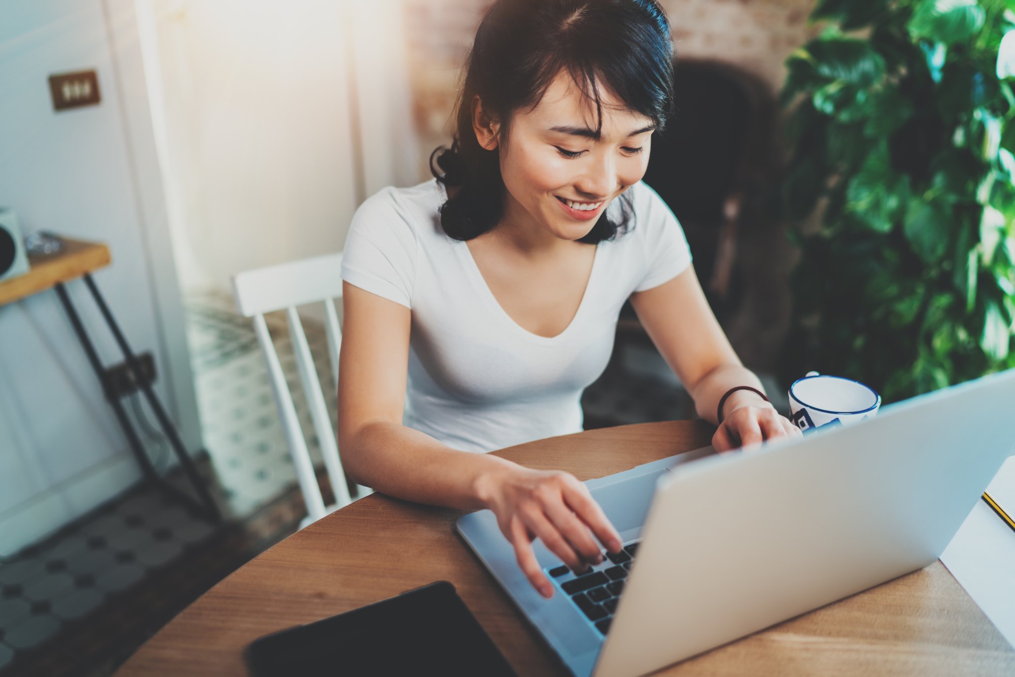 woman at kitchen table on laptop