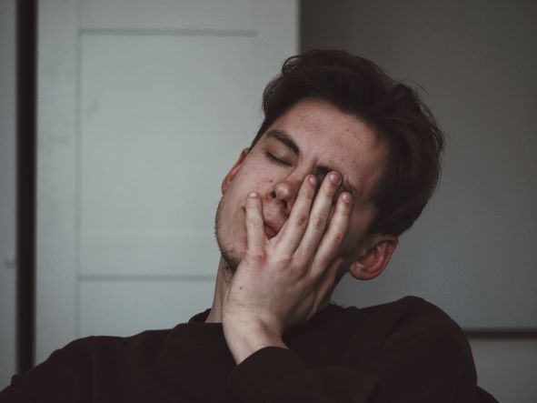 male patient holding face and suffering from toothache