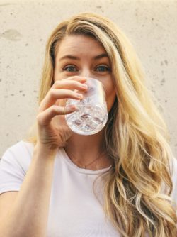 woman drinking water and suffering from Xerostomia