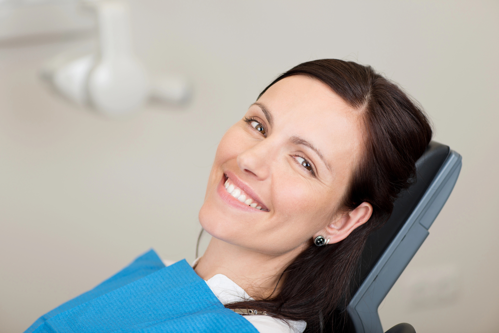 woman in dentist chair, smiling at the camera