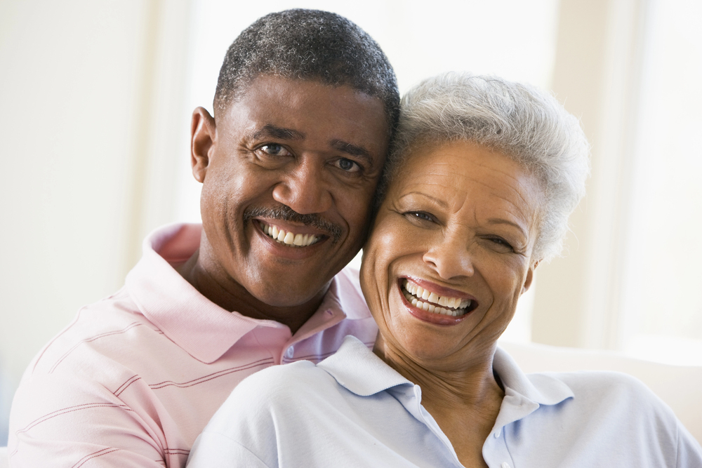 older black couple wearing collared shirts and smiling at the camera